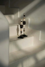 Totem décoratif en céramique noir et blanc sur socle carré sombre