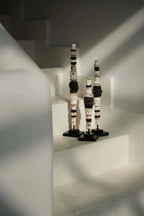 Trois totems sculpturaux élancés en disques céramiques noir et blanc sur socle métallique