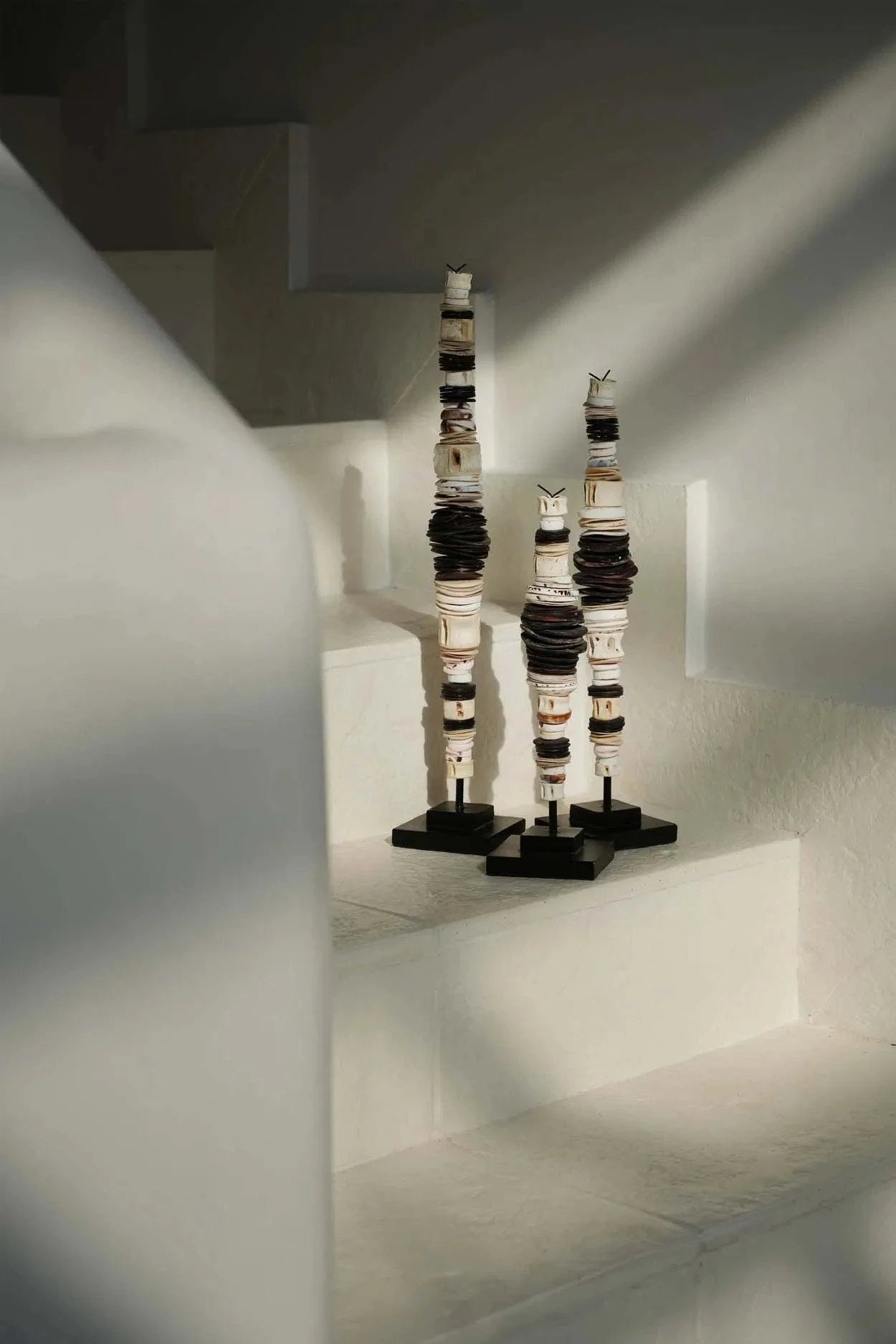 Trois totems décoratifs empilés en coquillage noir naturel sur support bois