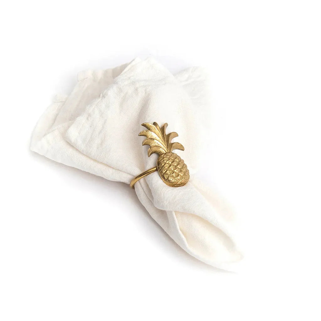 Serviette de table blanche avec anneau d’ananas doré.