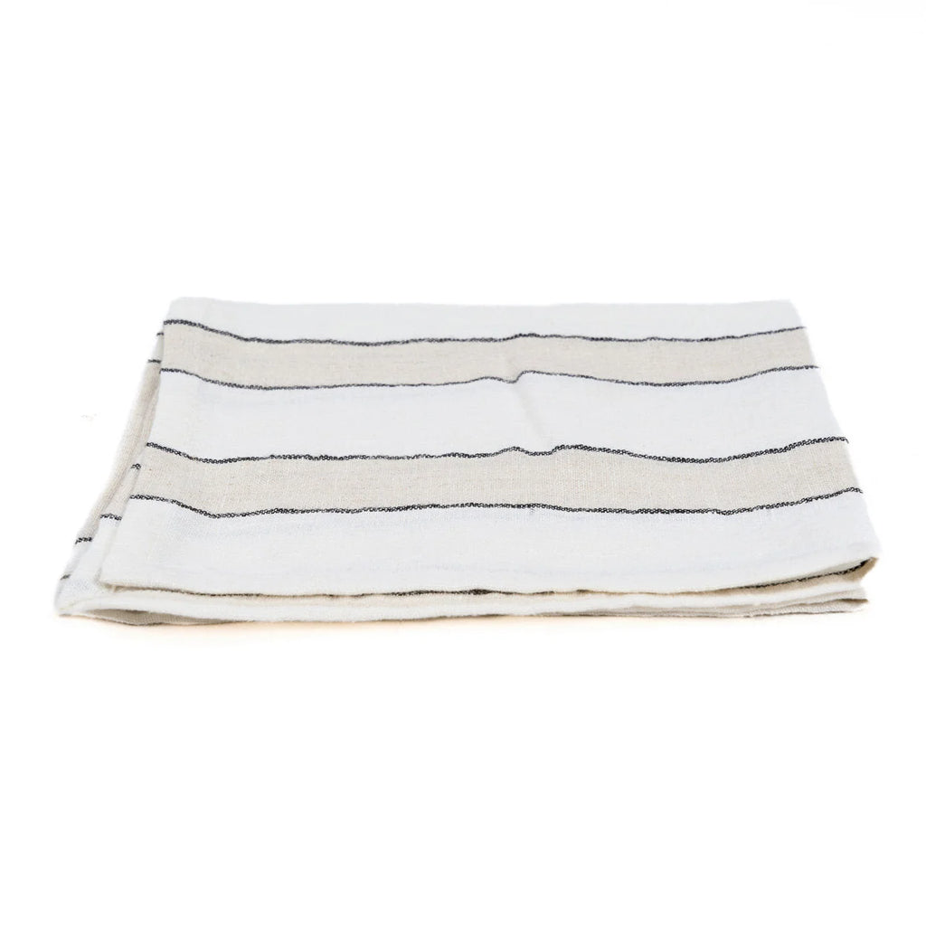 Serviette en lin blanc rayé noir horizontalement, pliée élégamment