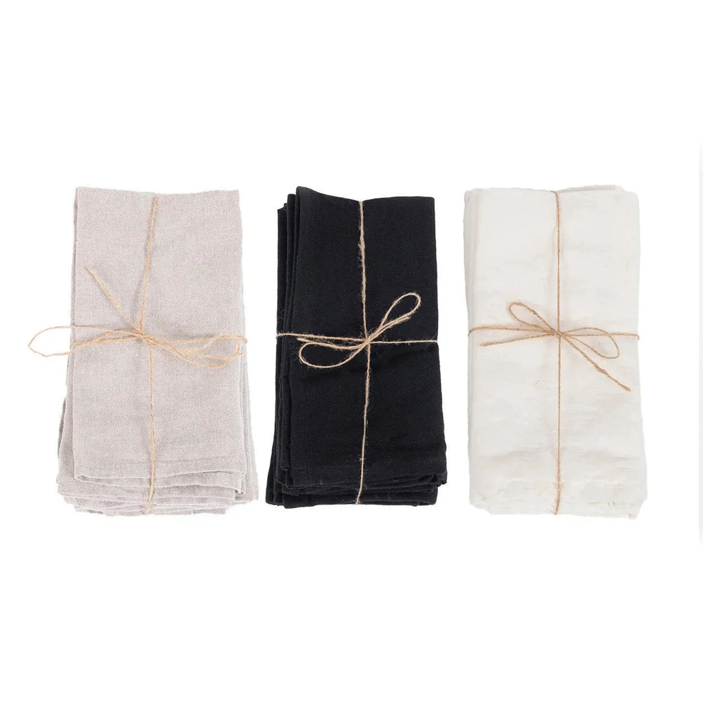 Trois paquets de serviettes en lin naturel beige, noir et blanc, liés avec de la ficelle