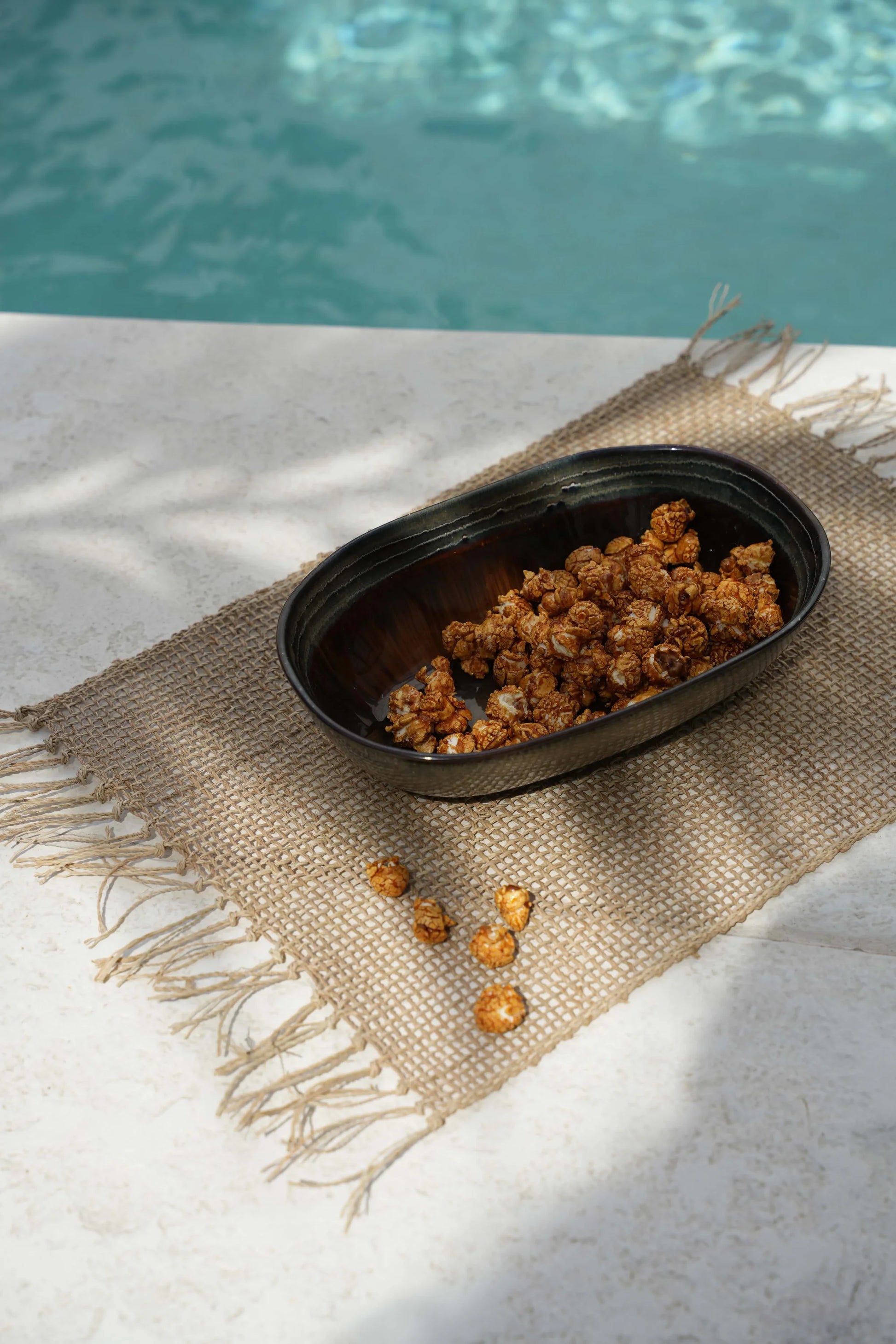 Popcorn caramel dans un bol foncé avec le set de table en jonc de mer naturel tenseur