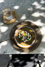 Plat artistiquement présenté avec garniture crémeuse sur le Set de Table Perlé Or 40