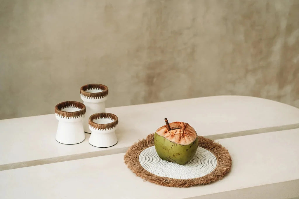Photo de boisson à la noix de coco avec paille sur le set de table en raphia blanc naturel