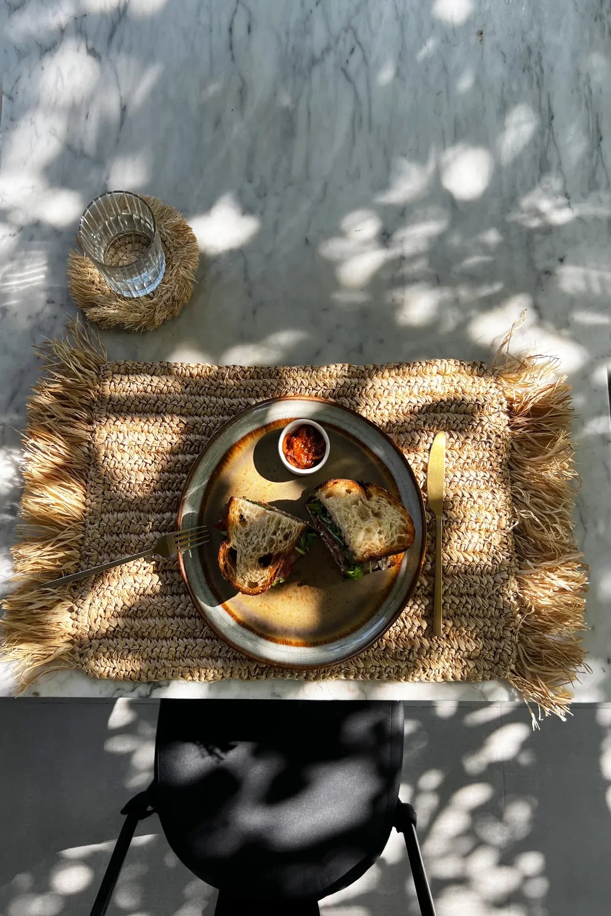 Assiette petit-déjeuner avec pain et sauce sur set de table en raphia naturel à franges