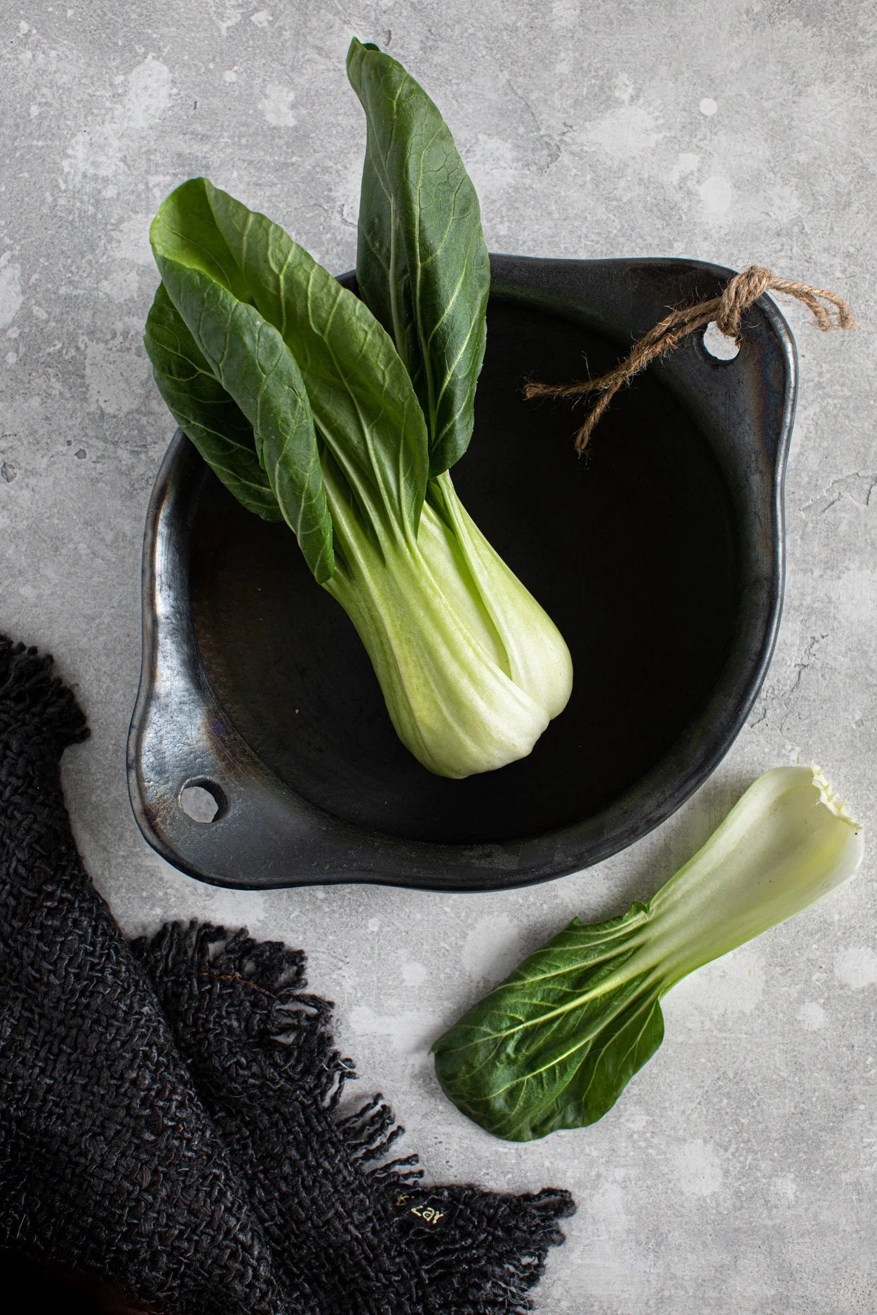 Bok choy frais dans bol céramique noir mat avec ficelle rustique