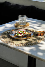Bruschetta sur une assiette avec un verre d’eau, service rond en jonc de mer coquillages
