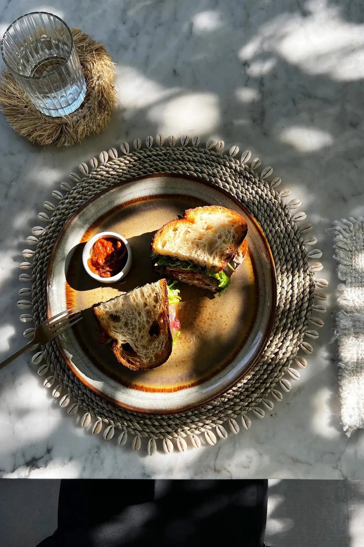 Sandwich sur une assiette décorative en jonc de mer avec coquillages naturels