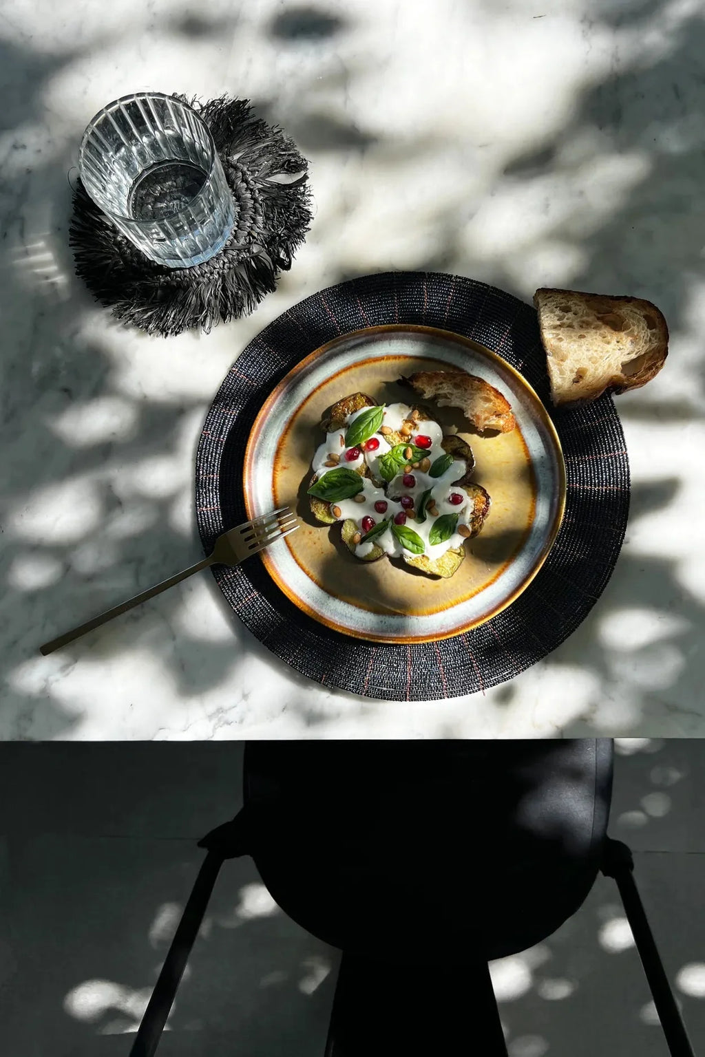 Plat de légumes rôtis avec sauce, basilic, grenade, servi avec pain, Set de table rond en perles noires motif rayonnant