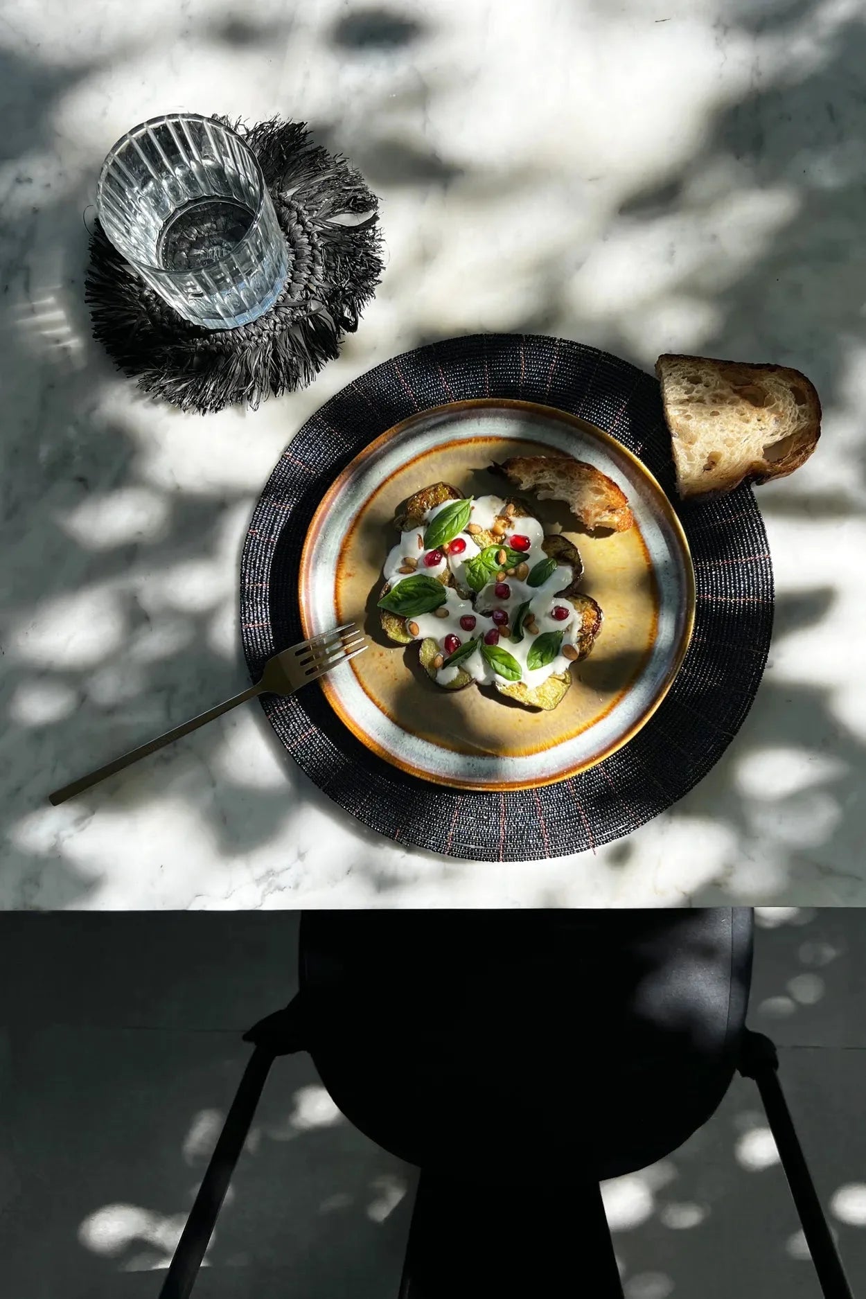 Plat de légumes rôtis avec sauce, basilic, grenade, servi avec pain, Set de table rond en perles noires motif rayonnant