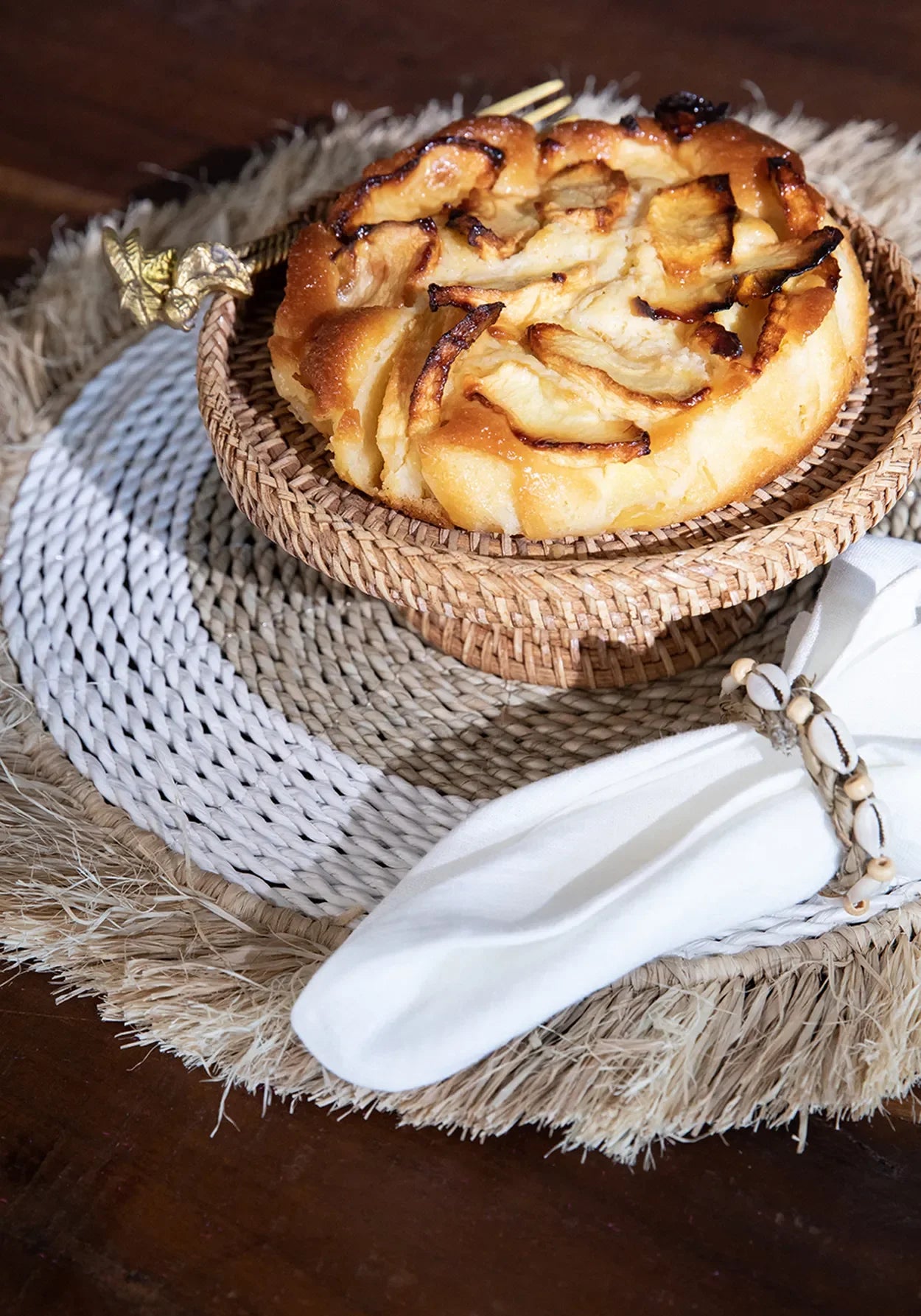 Gâteau aux pommes dans un panier en rotin pour le Set de table rond en raphia et herbe marine