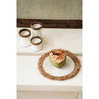 Cocotier frais avec boisson dans un set de table rond en raphia et herbe marine blanc naturel