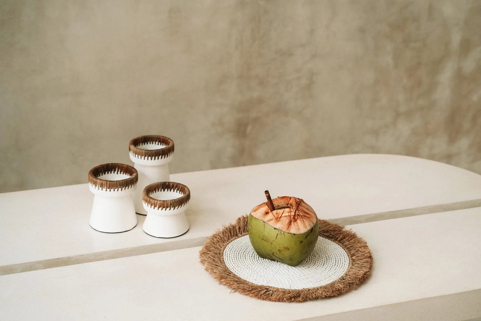 Cocotier vert avec paille sur un set de table rond en raphia et jacinthe d’eau