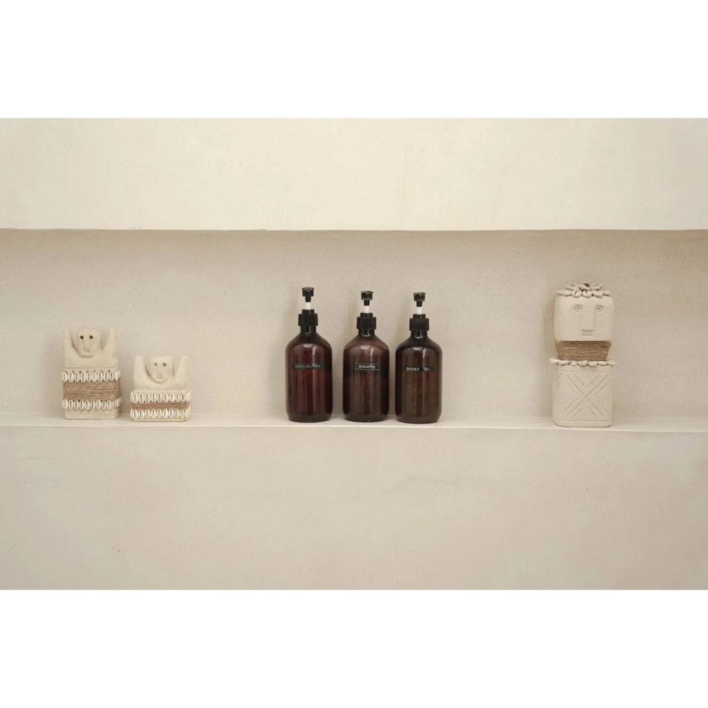 Trois bouteilles en ambre foncé et décorations en céramique sur une étagère