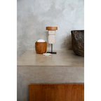 Cup en bois avec couvercle blanc et objet décoratif sur support noir dans Statue en grès silhouette humaine