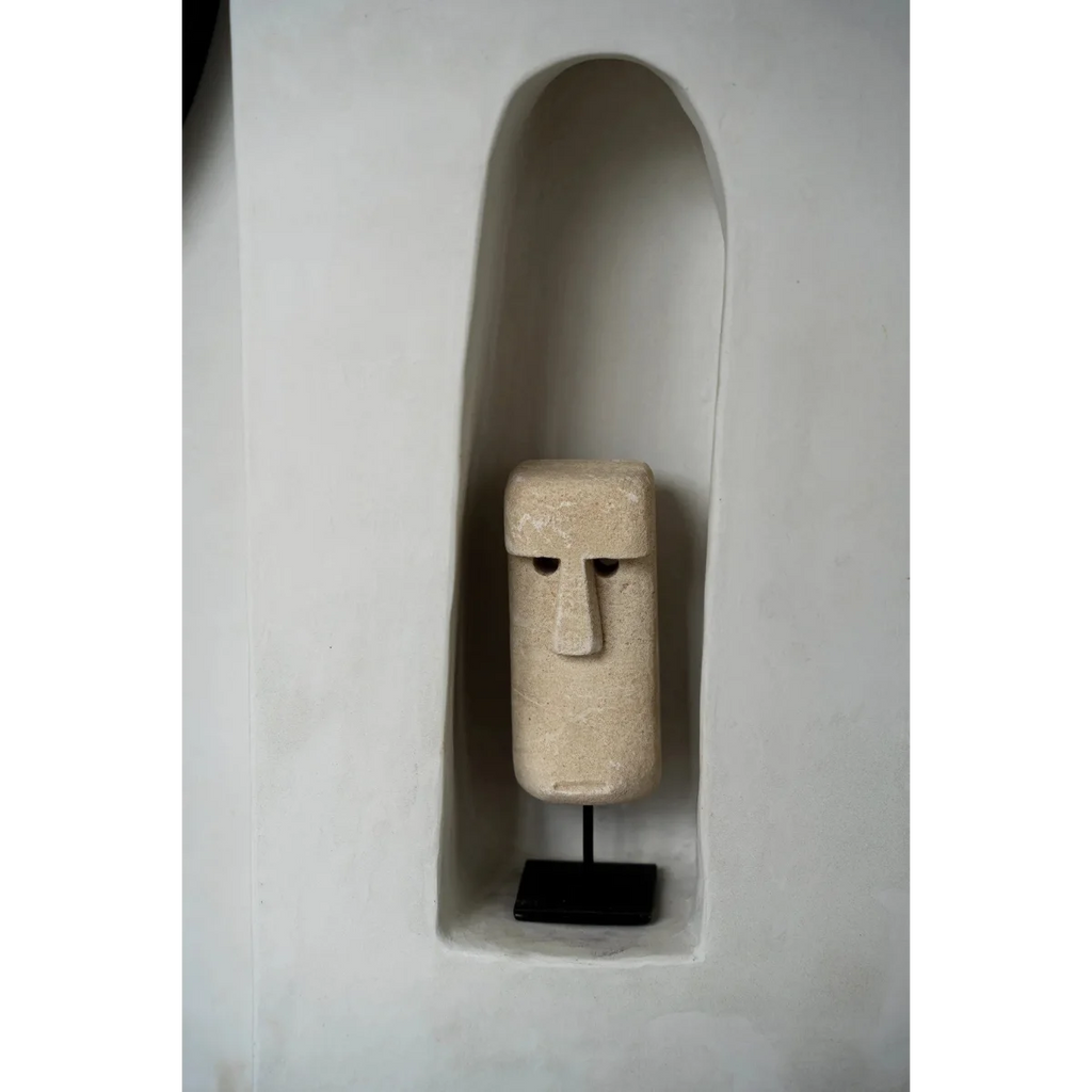 Sculpture visage en grès beige texturé avec nez et yeux profonds sur socle en bois