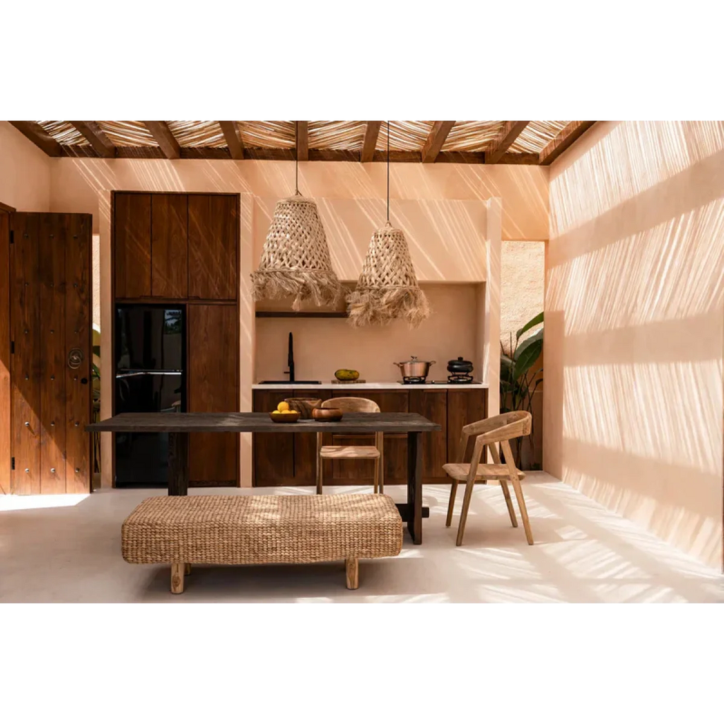 Espace repas avec table en bois foncé, banquette en tissé clair et chaises en bois clair