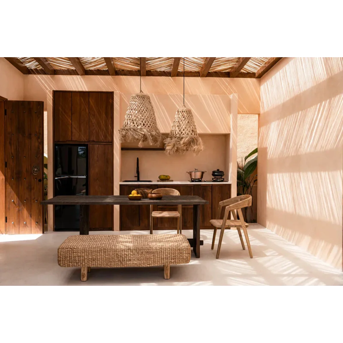 Espace repas avec table en bois foncé, banquette en tissé clair et chaises en bois clair
