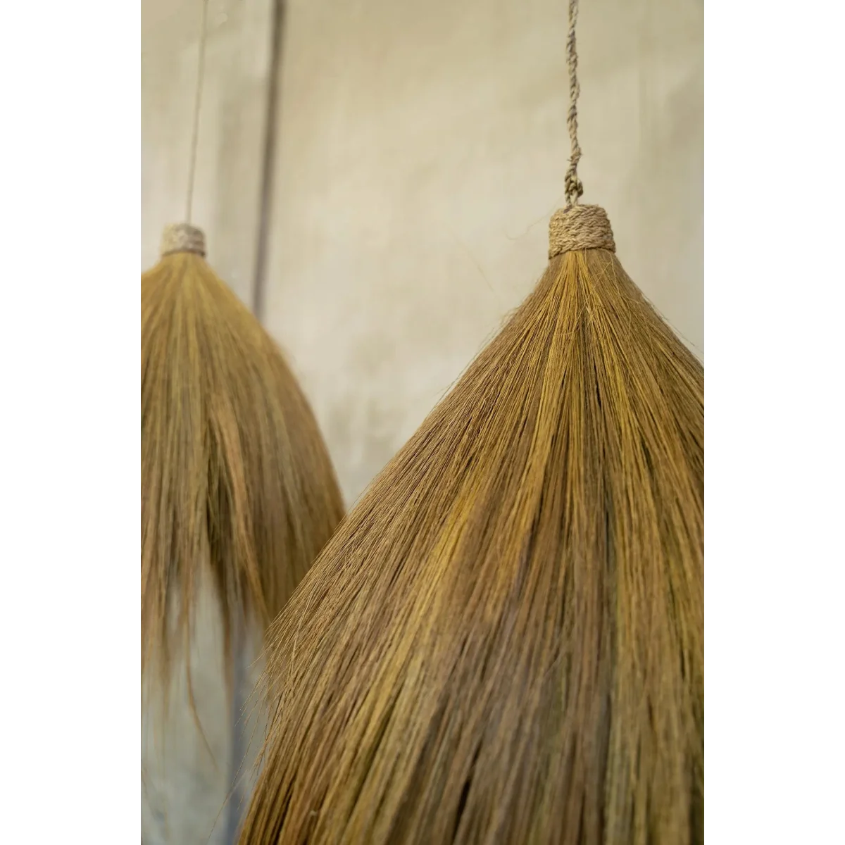 Deux balais décoratifs suspendus en fibres naturelles beige, 28x50 cm