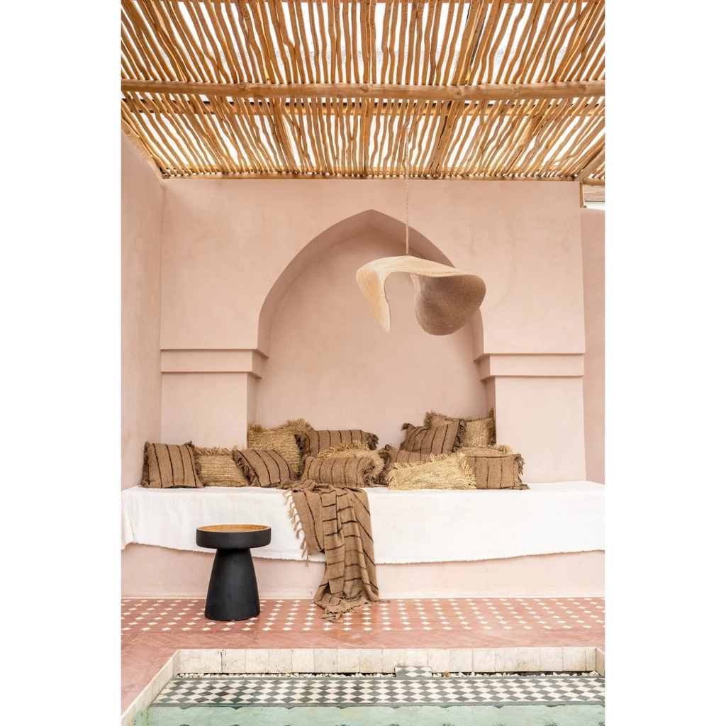 Espace de détente marocain avec coussins rayés et suspension en fibre tressée beige sable