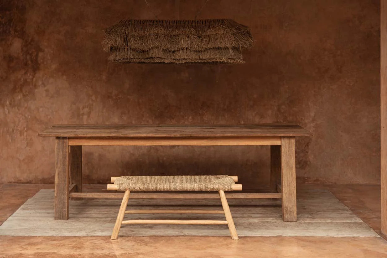 Table rustique en bois avec banc en jonc et suspension frangée en fibres naturelles beige paille au-dessus