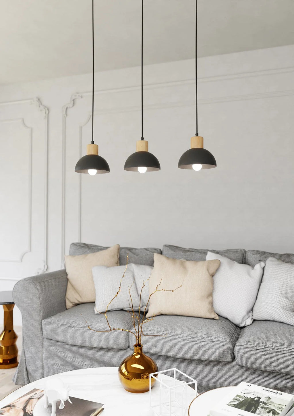 Trois suspensions linéaires en métal noir et bois au-dessus d’un sofa gris