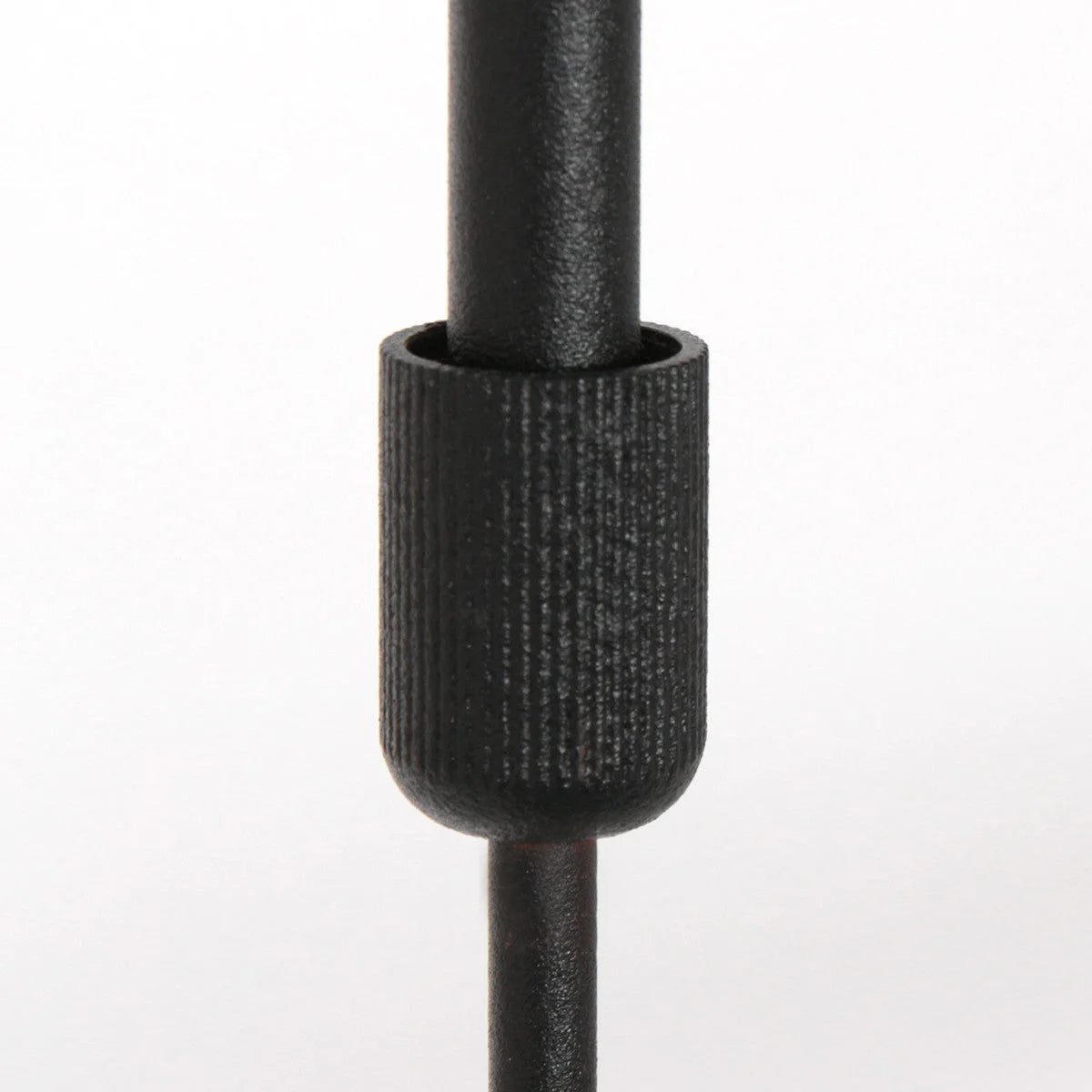 Bouton de réglage noir texturé sur un poteau en métal pour suspension moderne