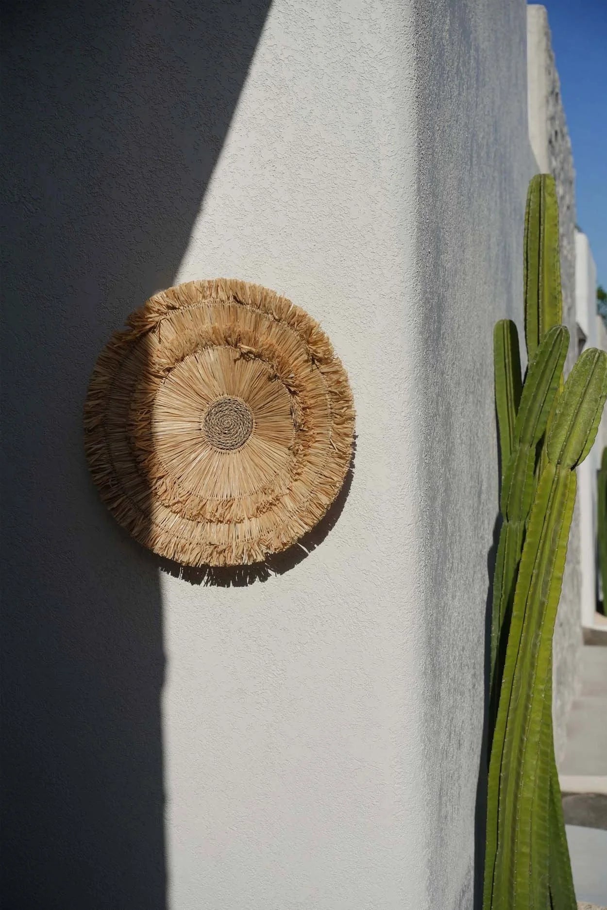 Décoration murale ronde en sisal naturel avec franges concentriques de 60 cm