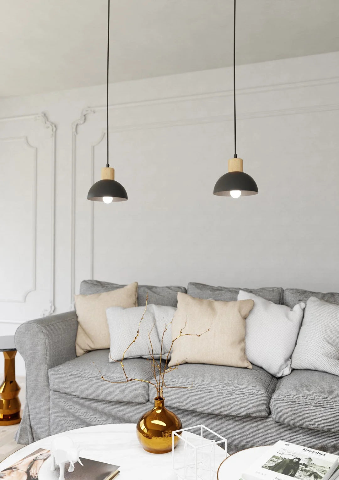 Deux suspensions noires en dôme métal et bois clair au-dessus d’un sofa gris