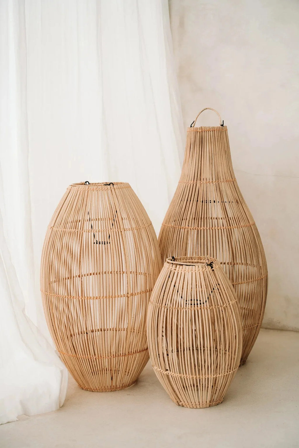 Suspension ovale en rotin tressé naturel avec trois lanternes en rotin de hauteurs variées