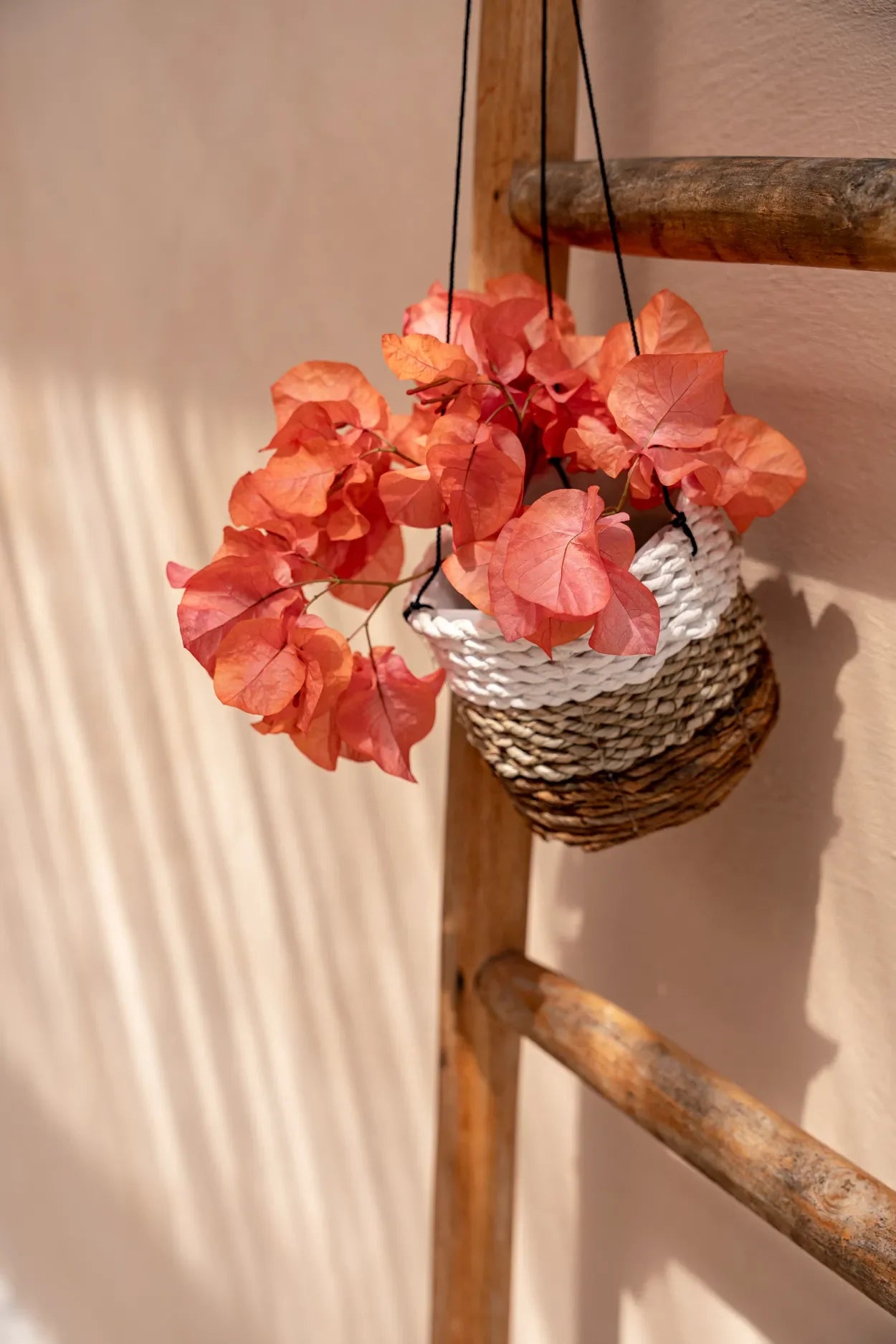 Panier suspendu de fleurs de corail dans la suspension en feuilles de bananier blanc et jonc de mer