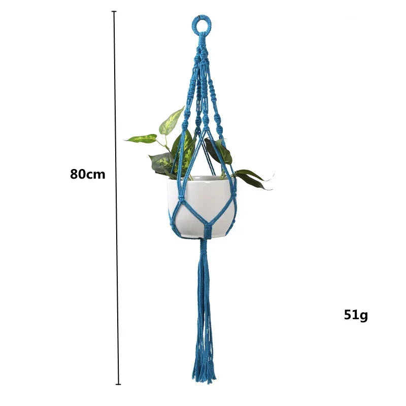 Suspension en macramé bleu rond avec franges décoratives et plante verte à l’intérieur