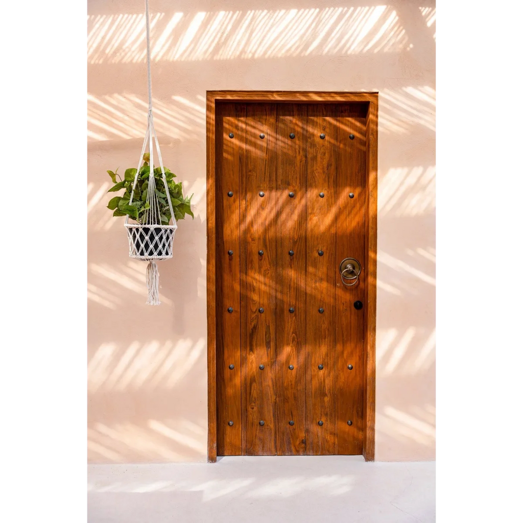 Porte rustique en bois avec bouton en métal et plante suspendue en macramé blanc cassé