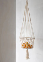 Support à fruits en macramé coton blanc avec pompon décoratif et oranges suspendues