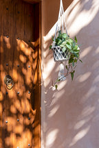 Support en macramé coton blanc avec plante verte suspendue et pompon décoratif