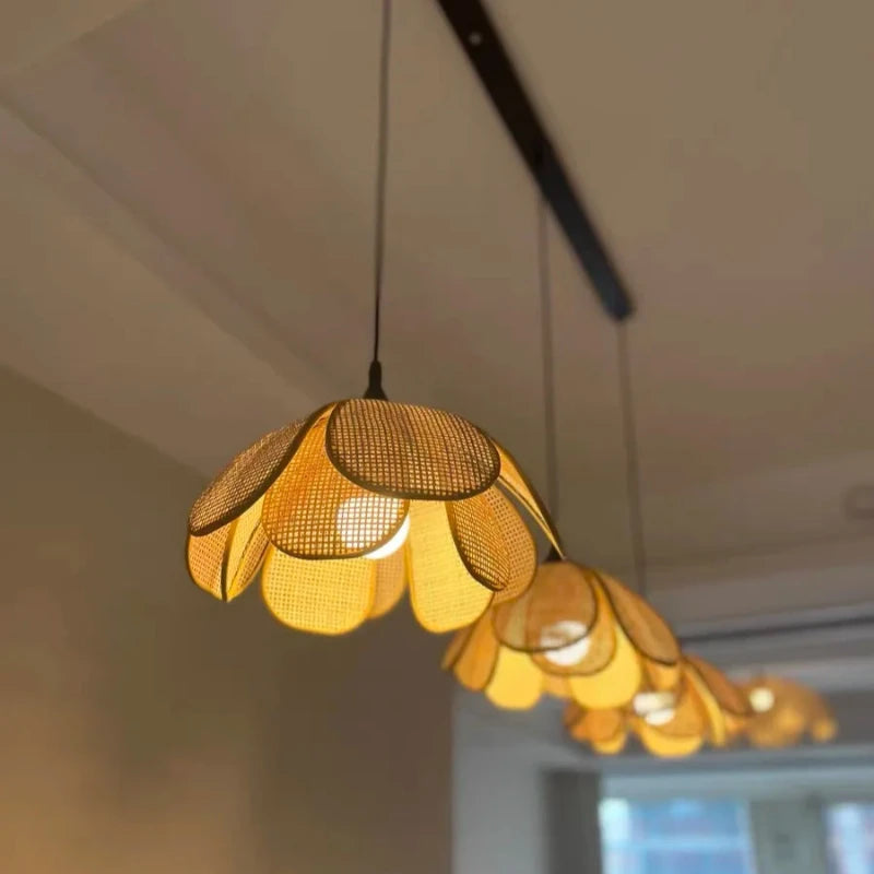 Suspension rotin à 3 lampes installée dans une cuisine avec un éclairage doux et tamisé.