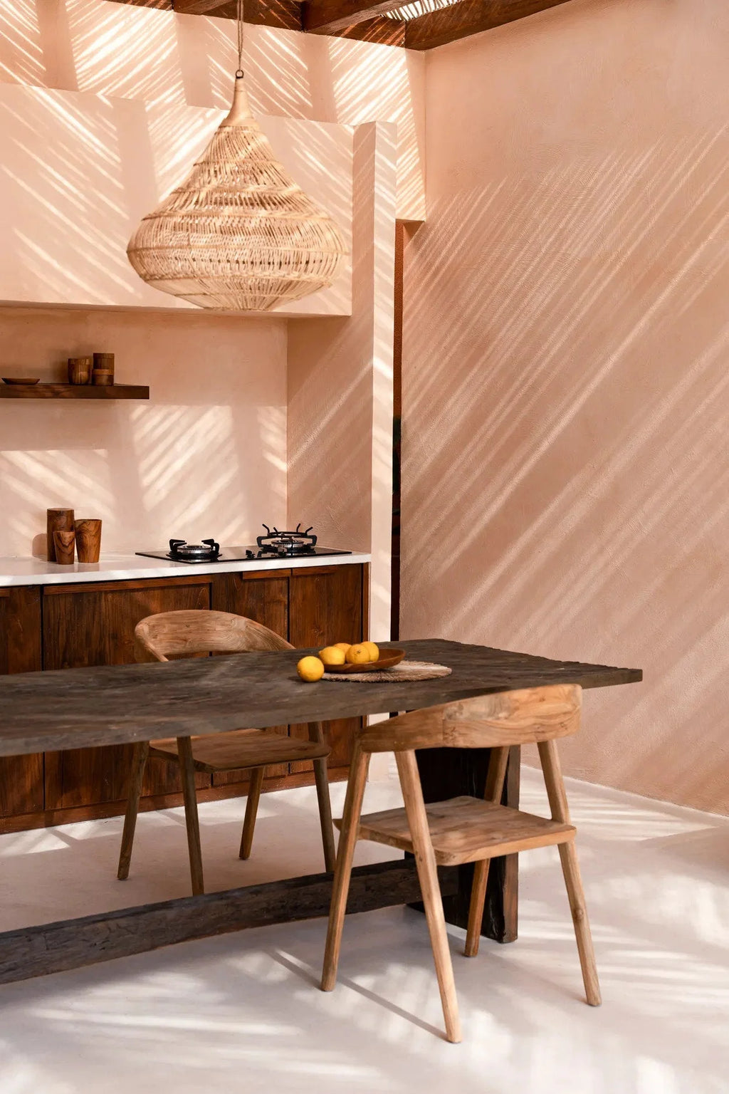 Suspension en rotin naturel forme goutte ajourée Ø55 cm au-dessus d’une table