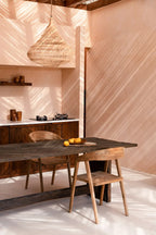 Suspension en rotin naturel forme goutte ajourée Ø55 cm au-dessus d’une table