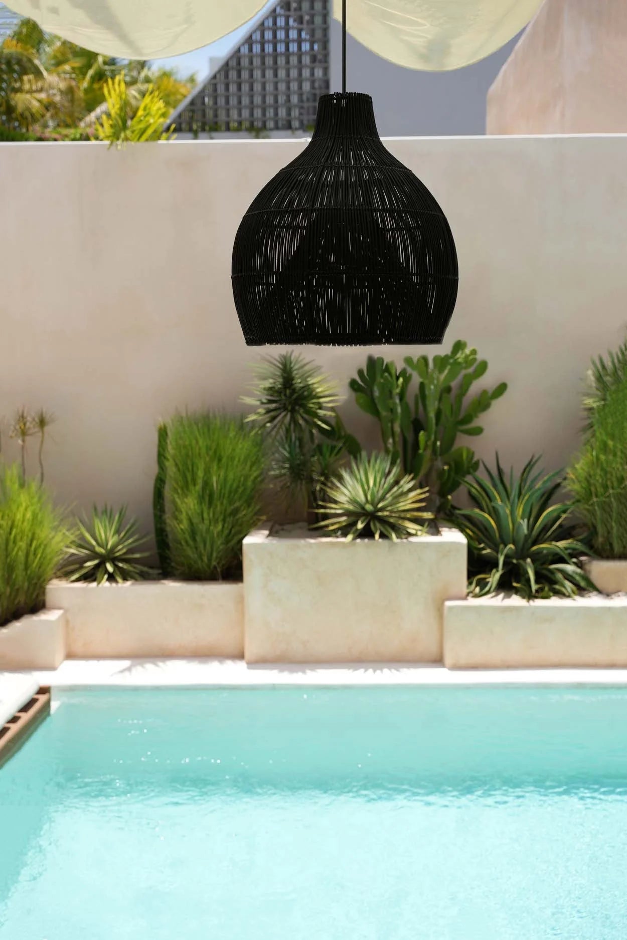 Suspension en rotin tressé noir forme goutte Ø50 cm au-dessus de la piscine