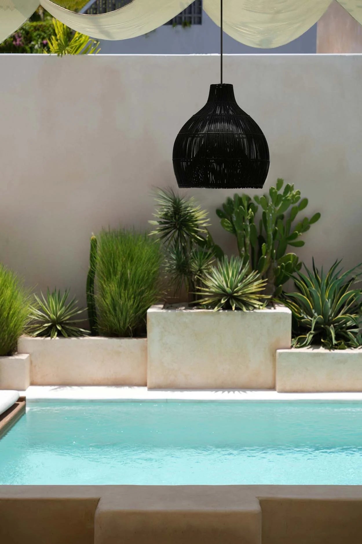 Suspension en rotin tressé noir forme goutte Ø50 cm au-dessus de la piscine