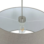 Abat-jour en tissu beige en forme d’évasé avec fixation en métal brossé et ampoule à filament exposé