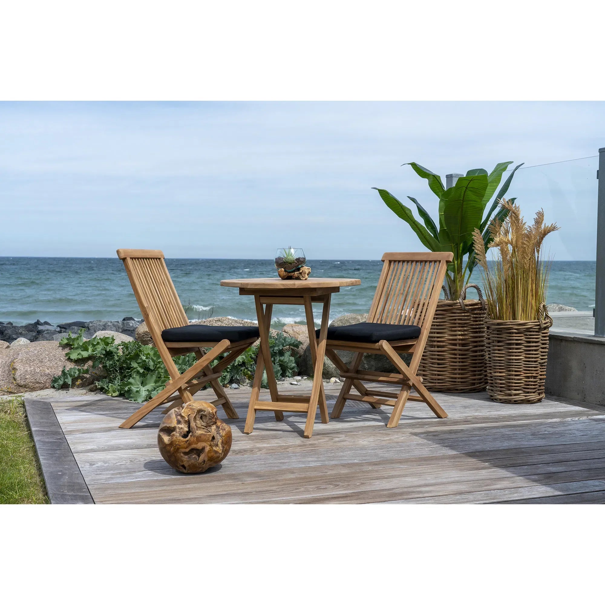 Table à manger ronde en teck naturel pour extérieur avec coussins noirs