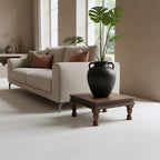 Vase en céramique noire texturée à deux anses sur table basse carrée en bois recyclé brun 33x33 cm