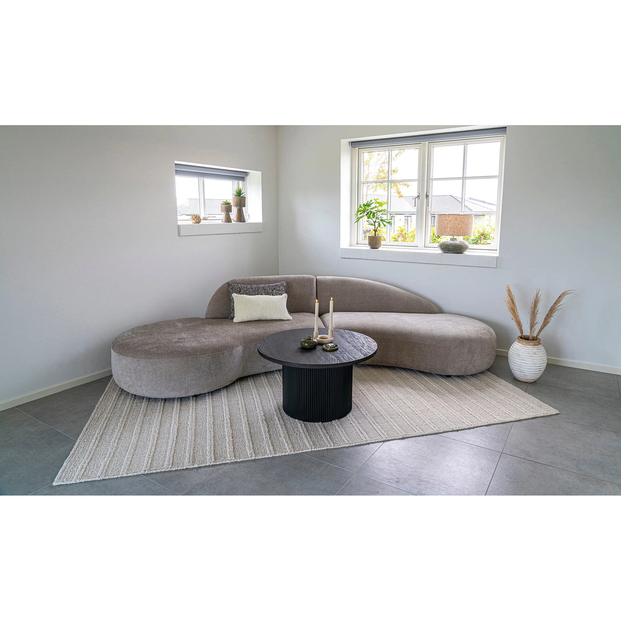Canapé en velours gris incurvé avec la table basse ronde en bois et base noire rainurée