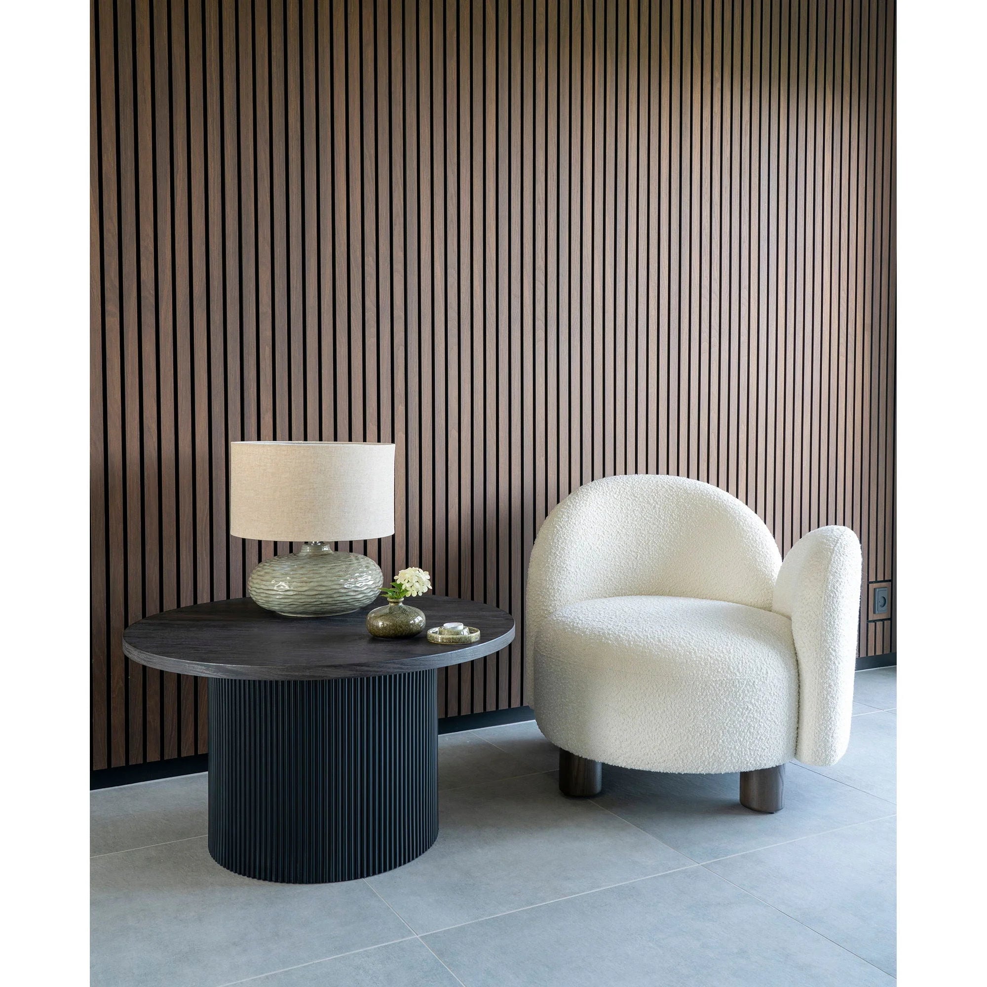 Chaise blanche douillette dans le salon avec la table basse ronde en bois et base noire