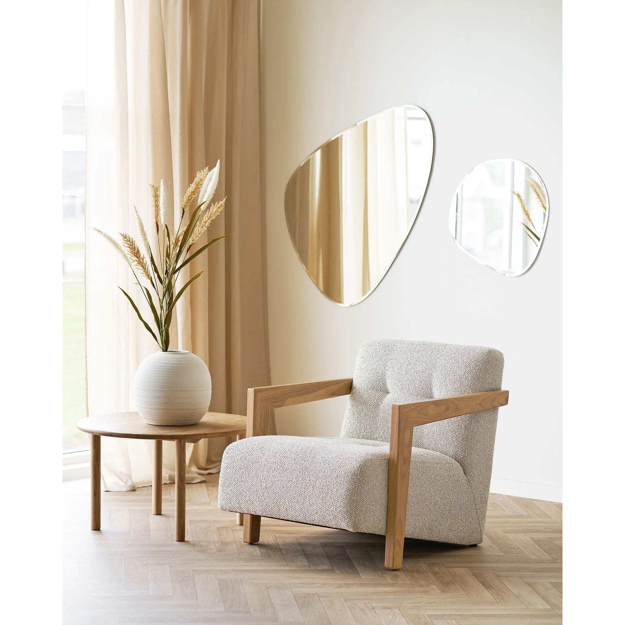 Fauteuil en bouclé crème avec bras en bois clair, parfait pour un salon chaleureux