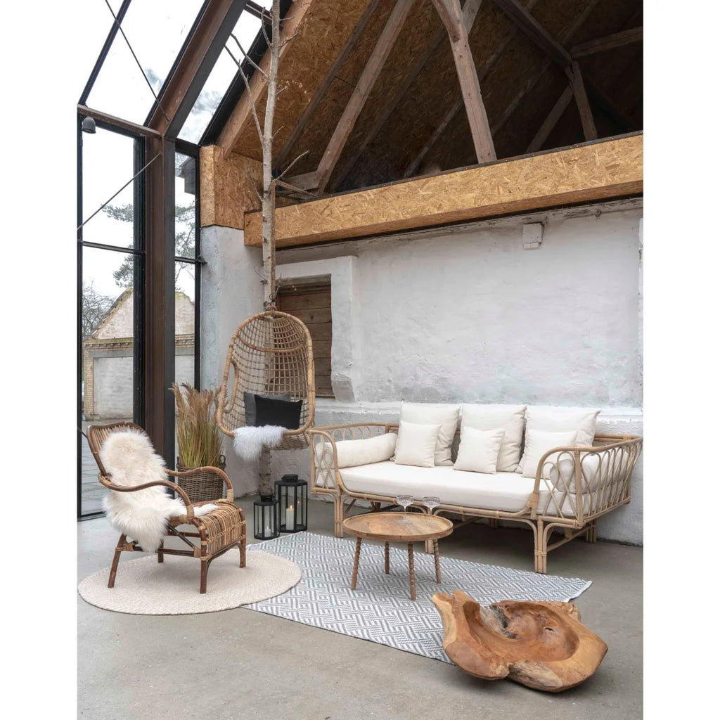 Canapé en rotin tissé avec coussins crème et cadre bois naturel