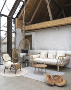 Canapé d’extérieur en rotin clair avec coussins crème pour un style naturel et confortable