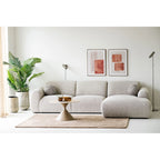 Canapé sectionnel en tissu beige texturé avec accoudoirs ronds et chaise longue